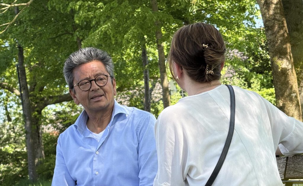 Rick Quentin in gesprek met een cliënte, buiten in het groen